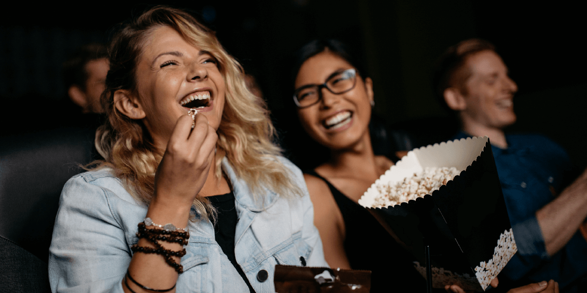 People smiling, laughing, eating popcorn