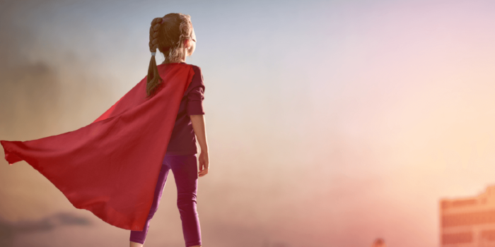 Young girl in cape/superhero costume