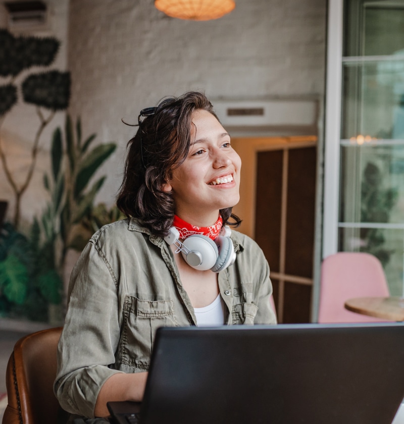 A young woman is using a laptop in a cafe.