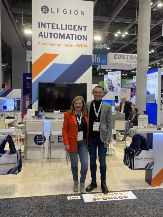 Loree Miller and Tyler Smith standing in front of Legion's booth at NRF 2023