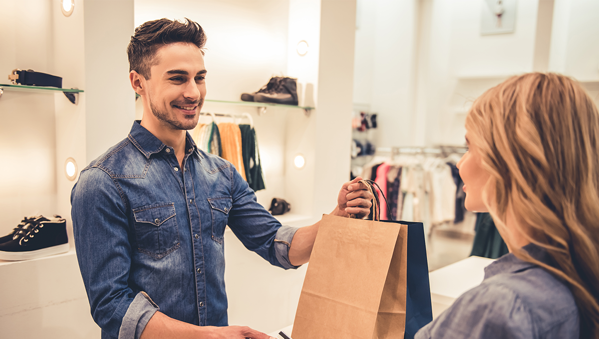 Handsome,Shop,Assistant,Is,Smiling,While,Giving,Purchases,And,Credit Handsome,Shop,Assistant,Is,Smiling,While,Giving,Purchases,And,Credit