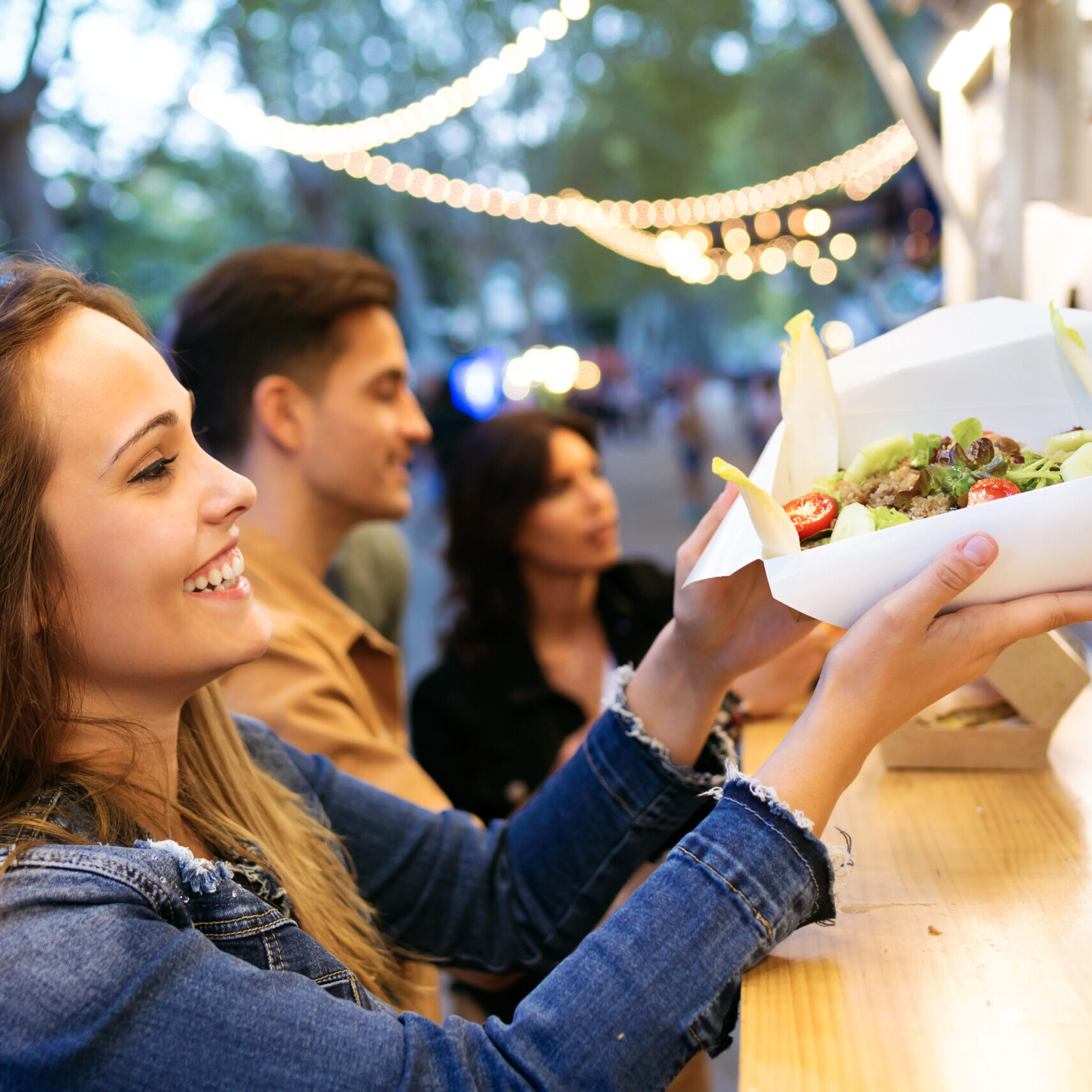 Smiling person receiving food order from counter